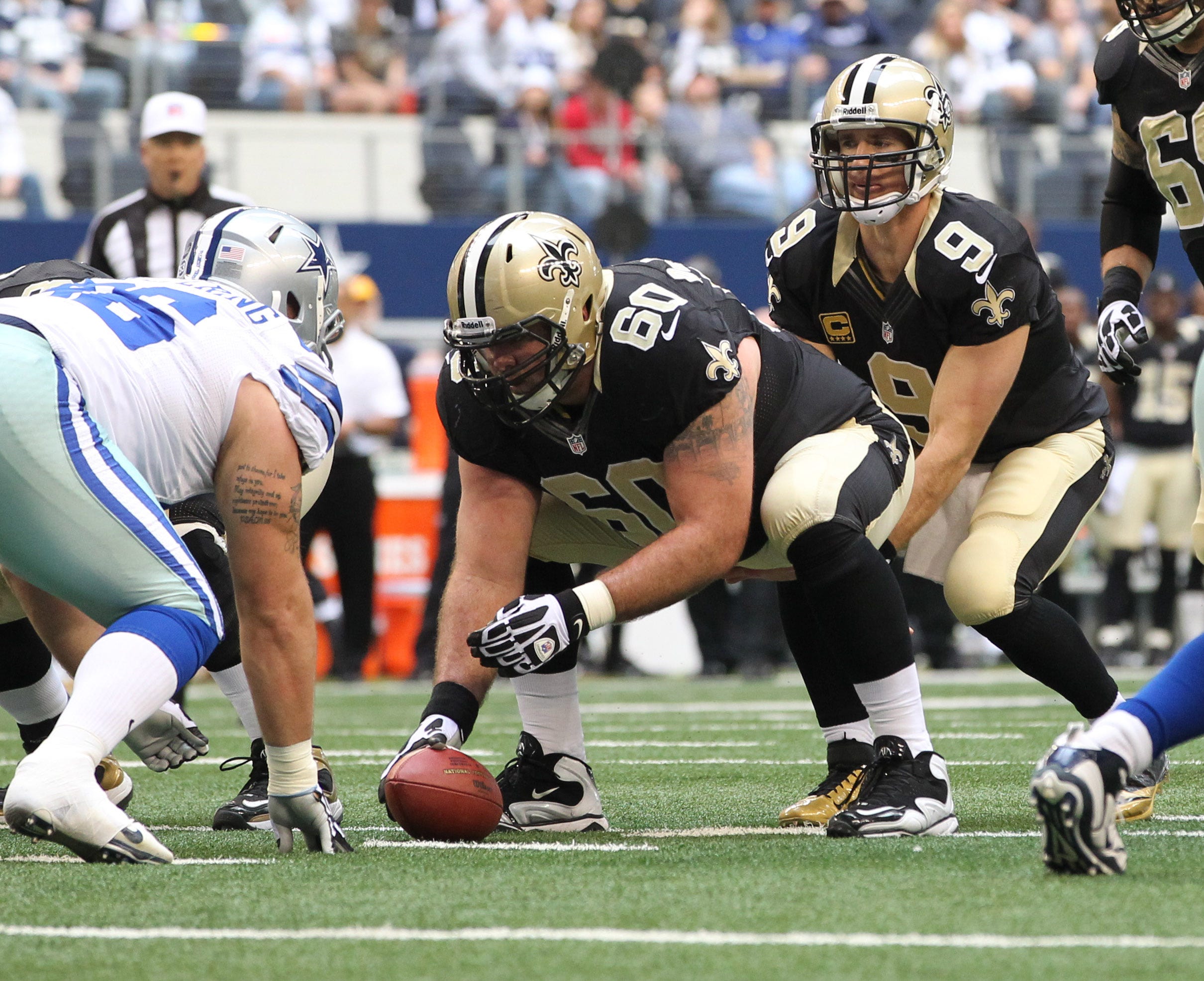 Dec 23, 2012; Arlington, TX, USA; New Orleans Saints quarterback Drew Brees (9) under center with Brian de la Puente (60) during the first half of the game against the Dallas Cowboys at Cowboys Stadium. The Saints beat the Cowboys 34-31 in overtime. Mandatory Credit: Tim Heitman-USA TODAY Sports